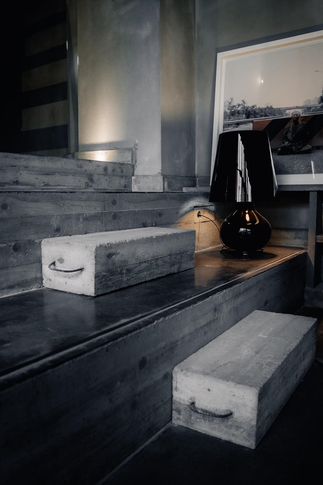 Gradini in legno e cemento, lampada da tavolo, luce calda
